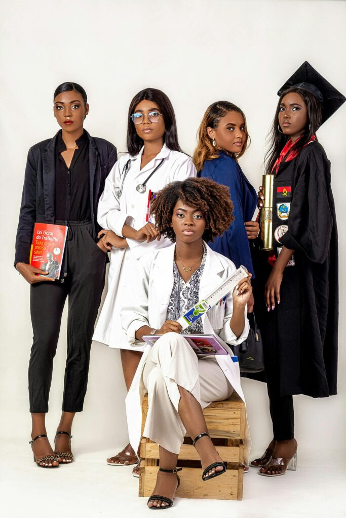 Five women in diverse professional outfits pose confidently against a white background.